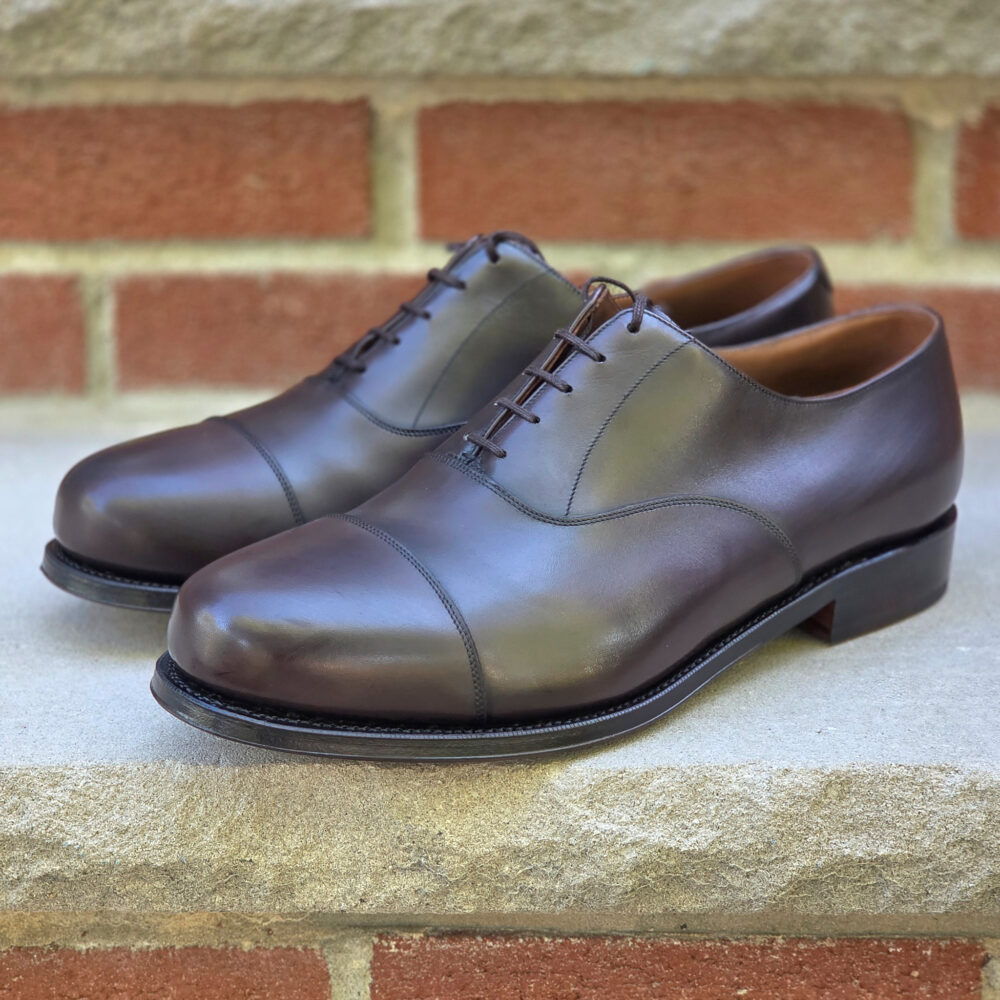 Brown leather dress shoes with a smooth finish and cap toe design.