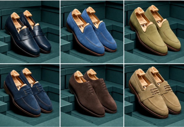 A collection of six pairs of stylish shoes in various colors, including navy, blue, green, and brown, displayed with wooden shoe trees.