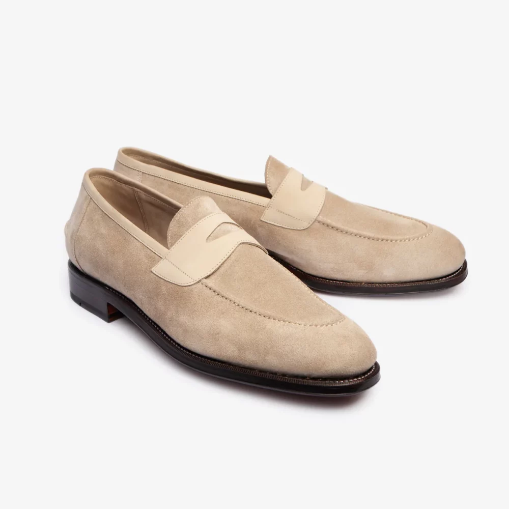 Beige suede loafers with a light beige accent.