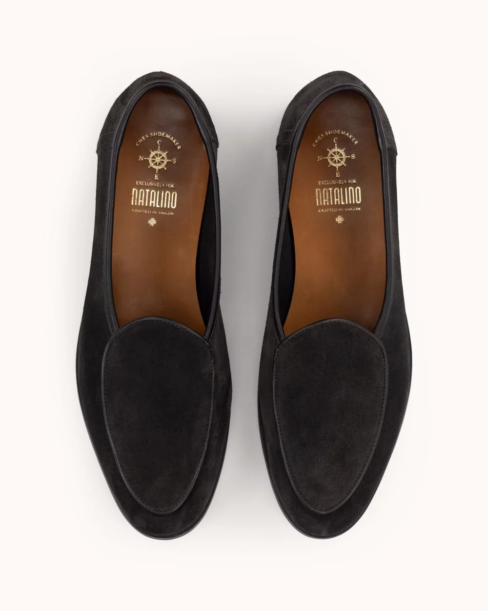 Two black suede loafers with a smooth finish and brown insoles.