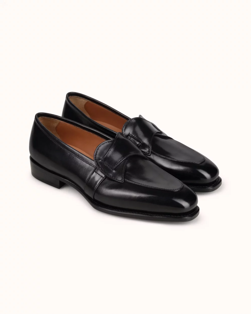 A pair of black leather loafers with a smooth finish and a rounded toe.
