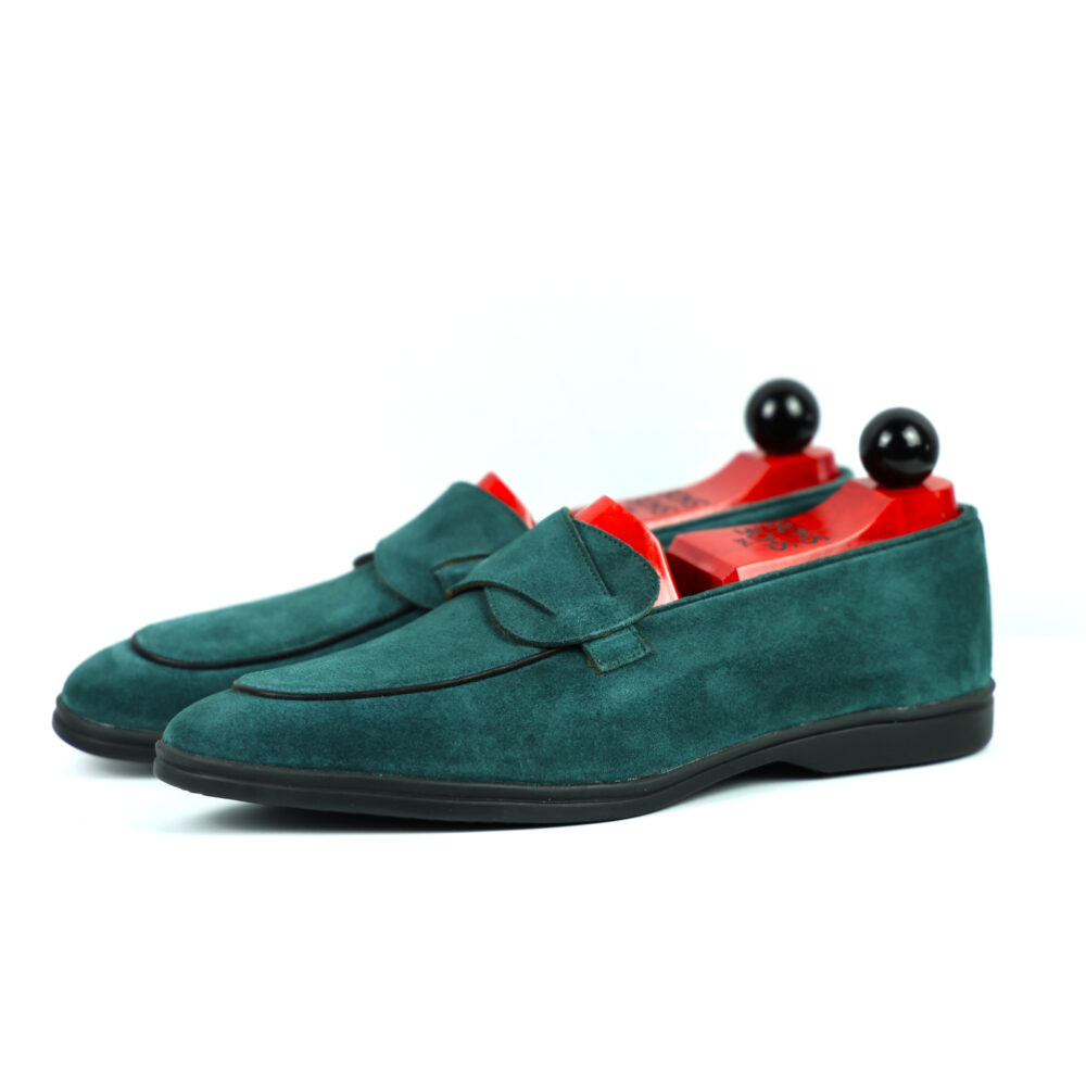 Teal suede loafers with red insoles and black shoe trees.