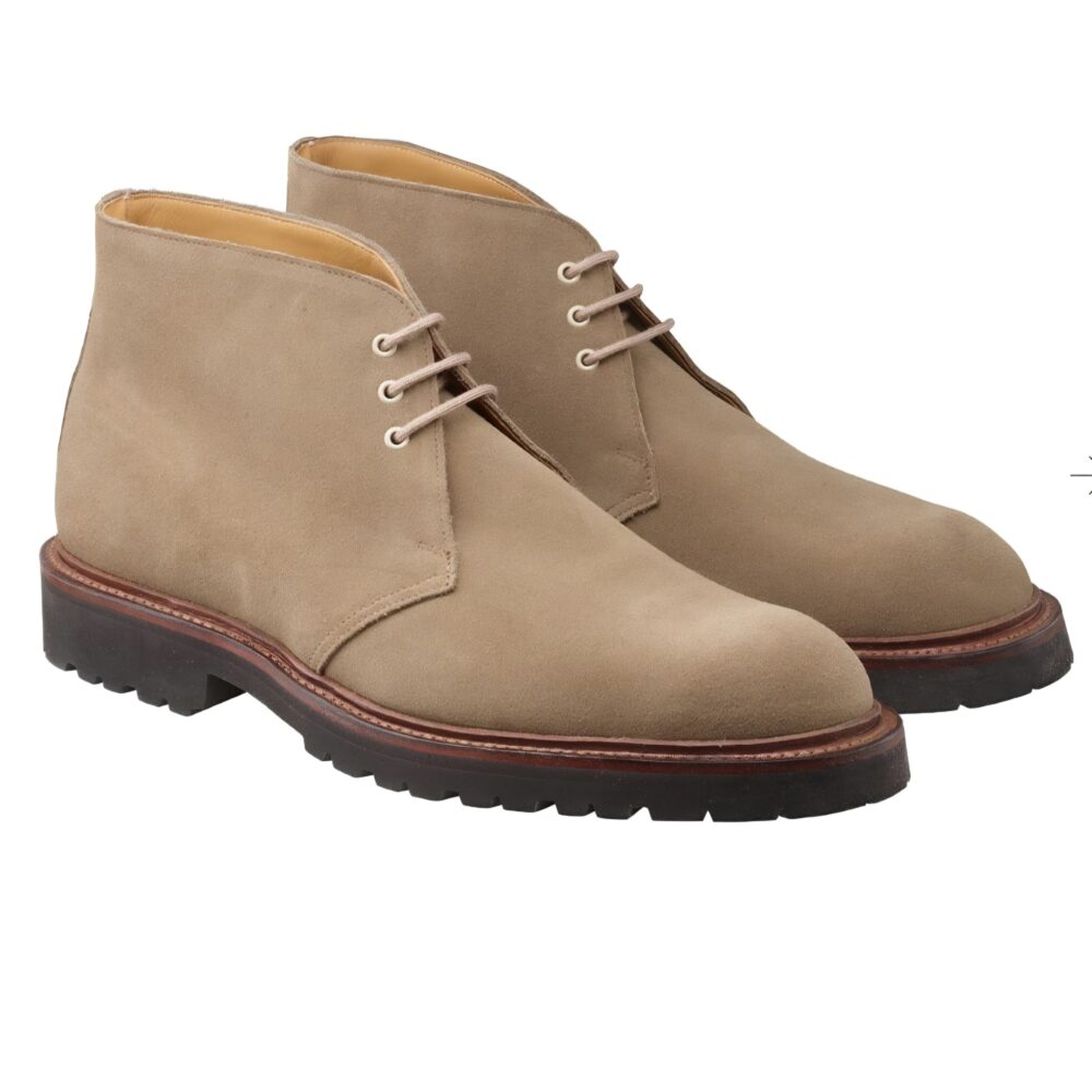 Beige suede chukka boots with brown rubber soles and laces.