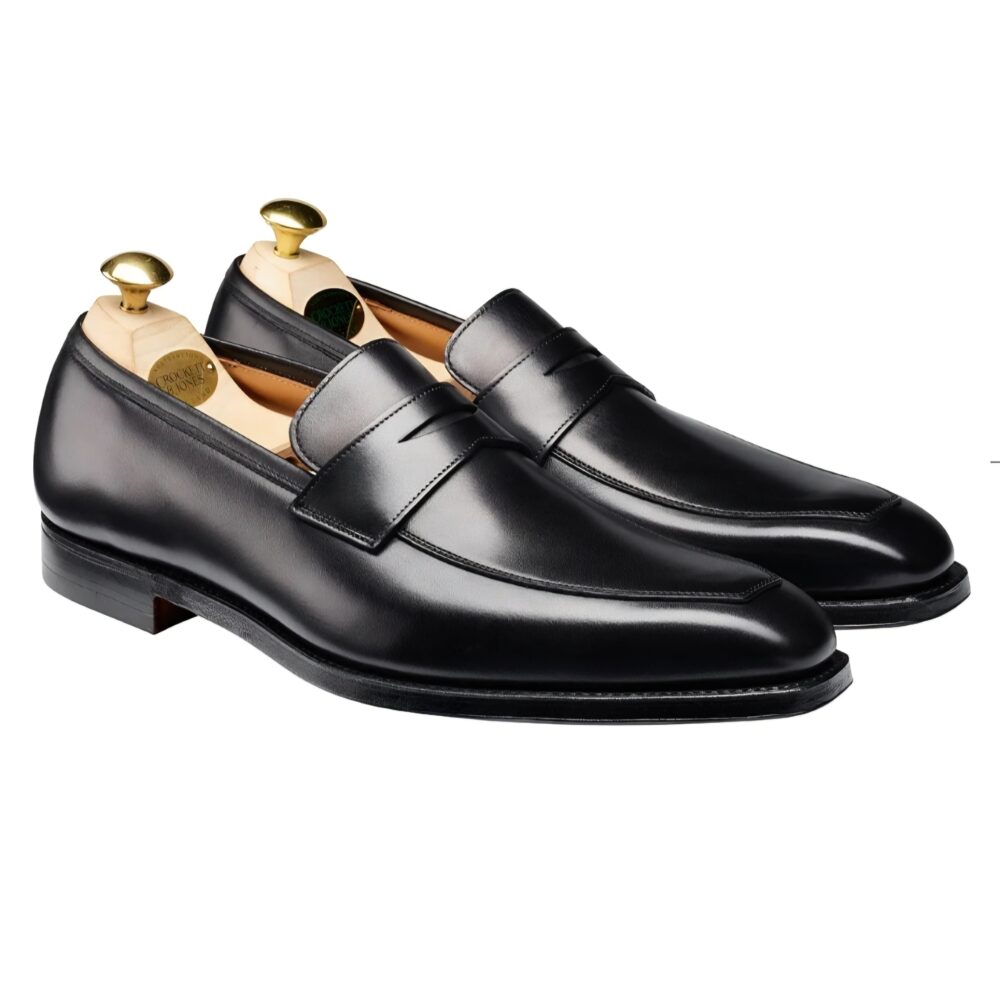 A pair of black leather loafers with wooden shoe trees inside.