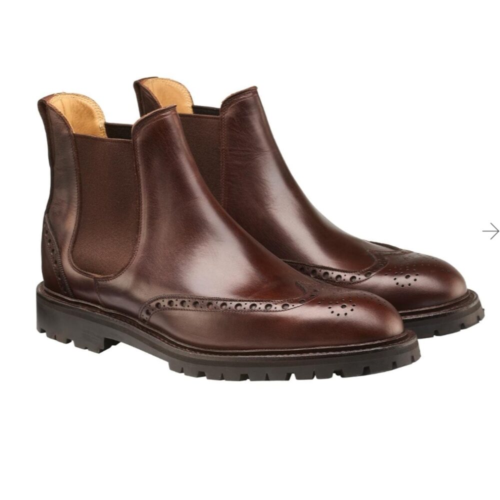 Brown leather Chelsea boots with decorative brogue detailing and a sturdy black sole.