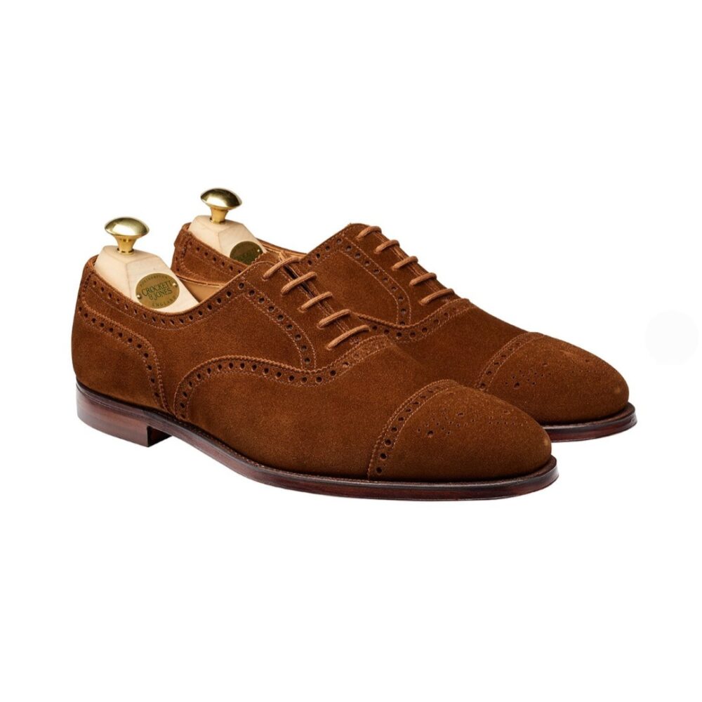 Brown suede dress shoes with decorative perforations and leather soles.