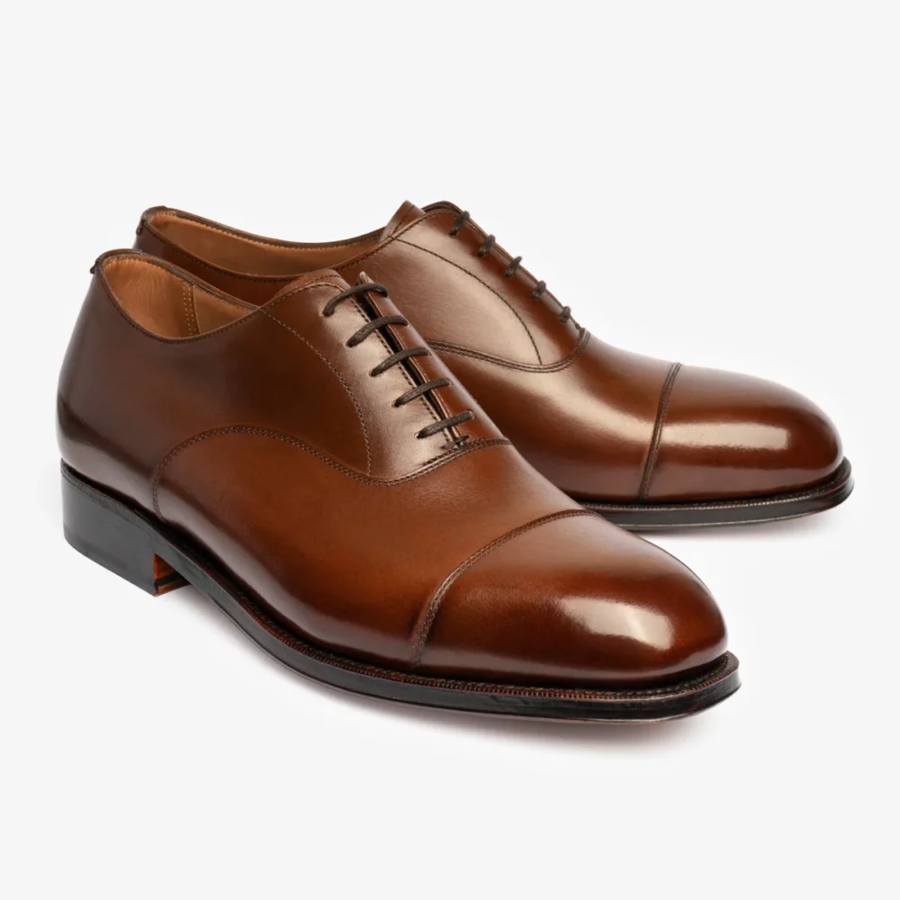 Brown leather dress shoes with a cap toe and lace-up design.