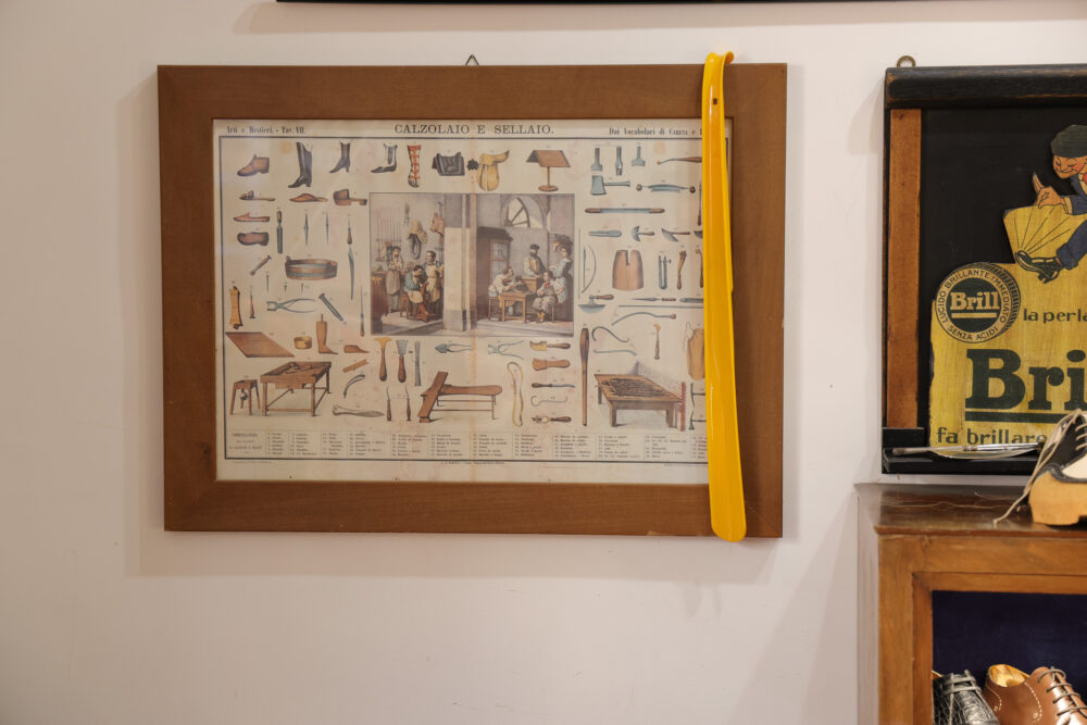 A framed illustration titled "Calzolaio e Sellato" featuring various shoemaking tools and a scene of shoemakers at work.