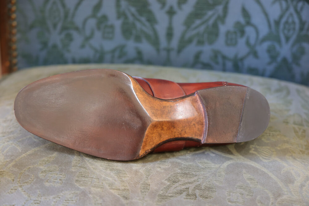 A close-up of the brown leather sole of a shoe with a polished finish.