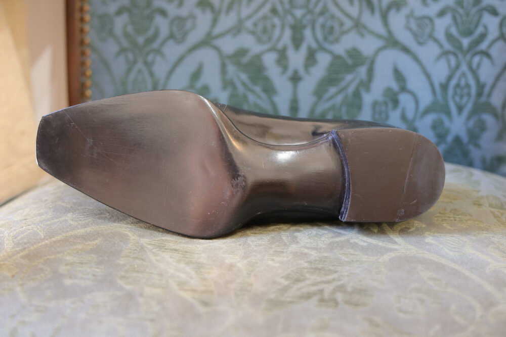 A close-up of the shiny black sole of a shoe, showcasing its sleek design and smooth finish.