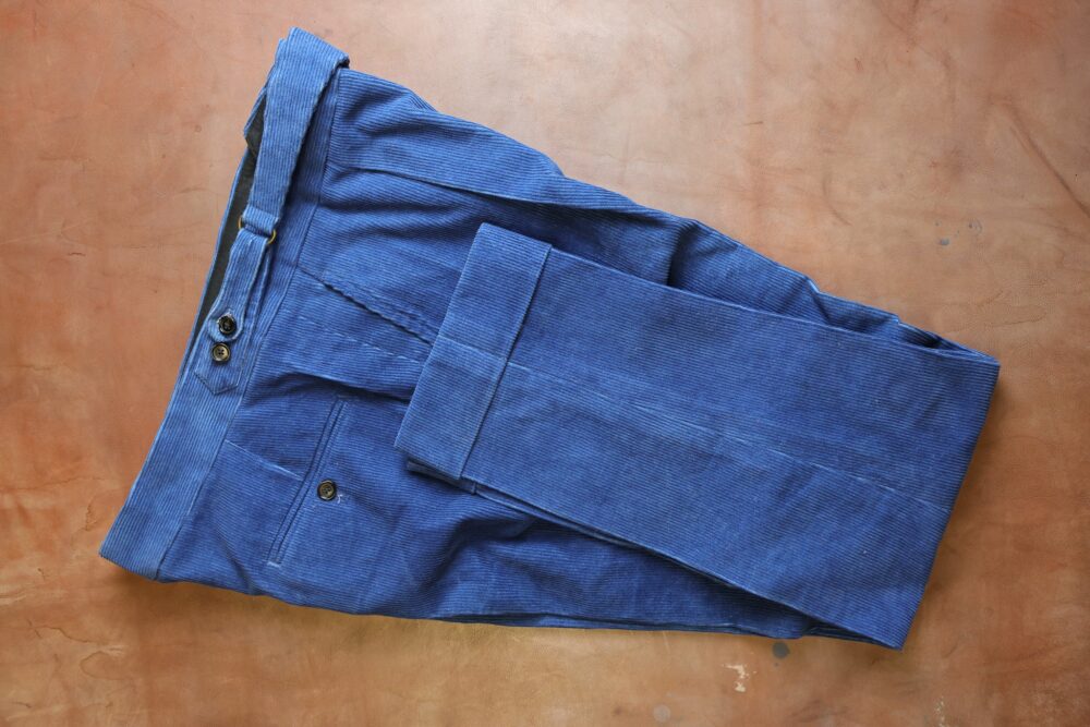 Blue corduroy pants laid flat.