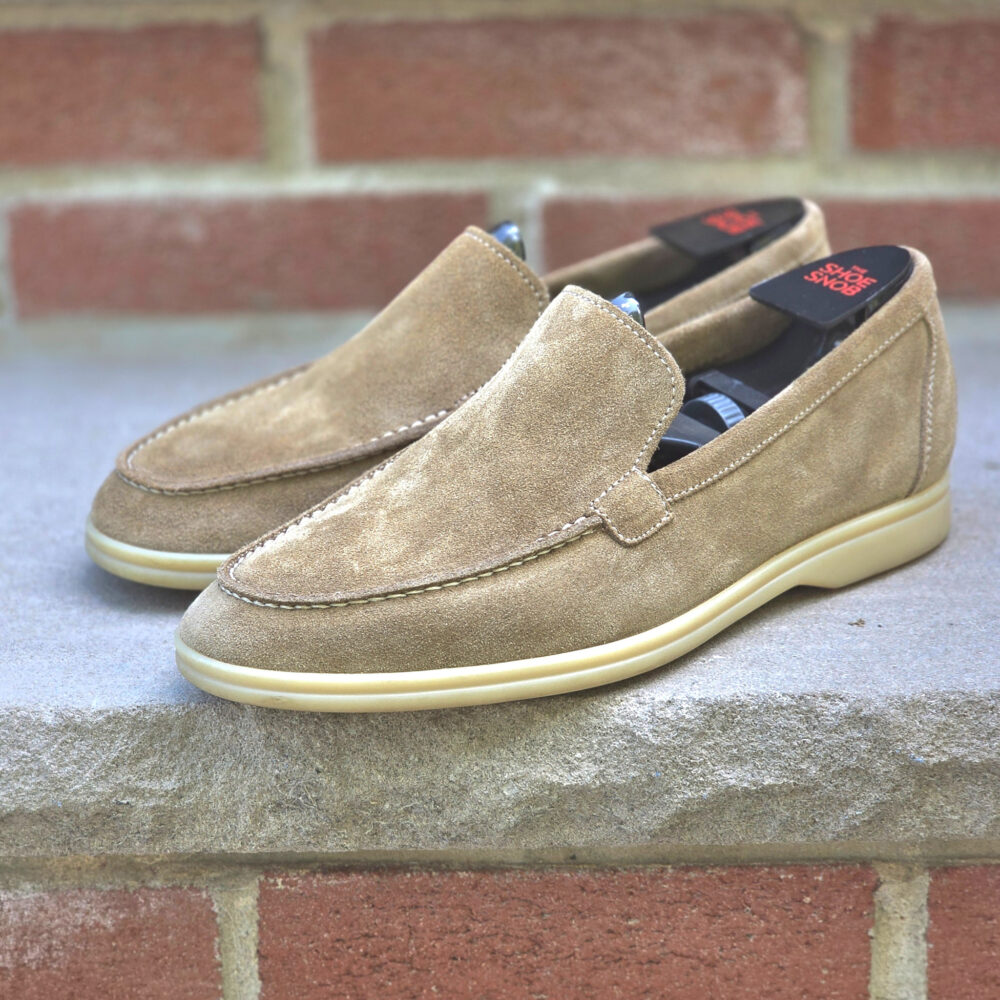 A pair of tan suede loafers with a cream-colored sole.