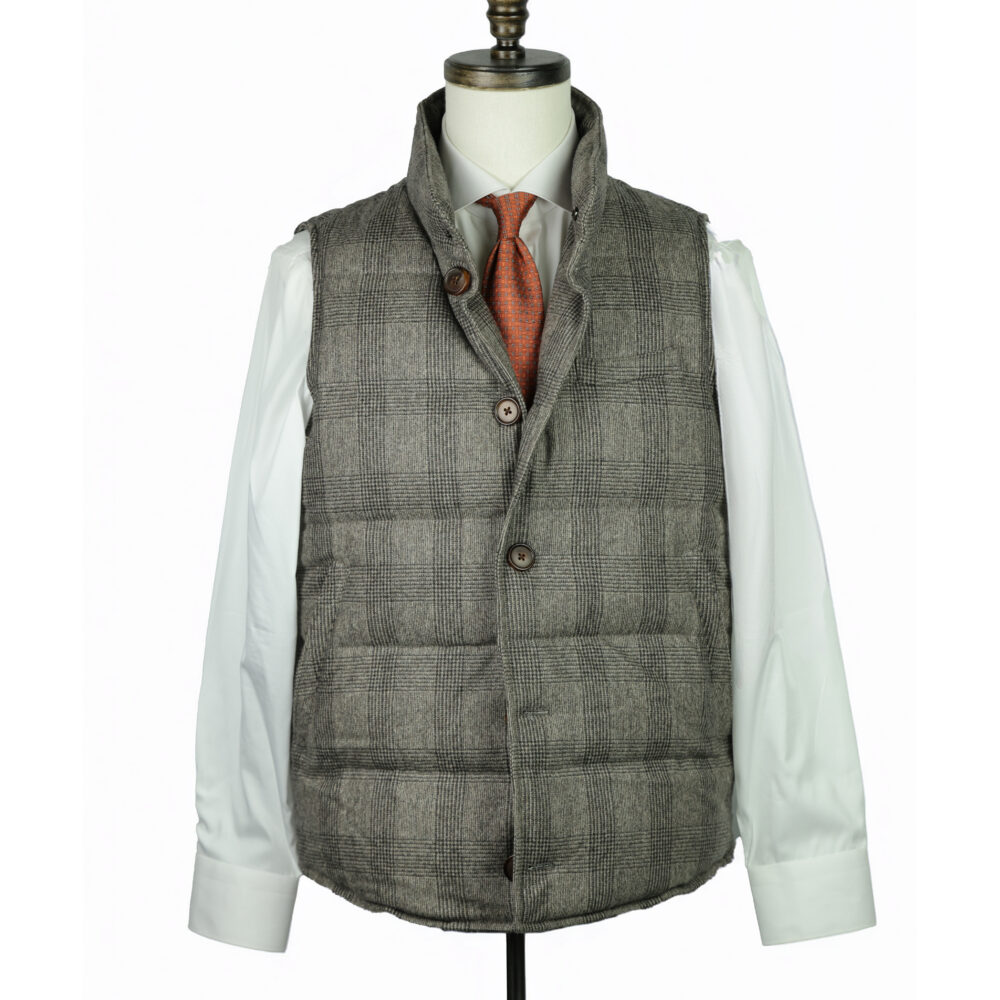 A gray plaid vest with a high collar and brown buttons, worn over a white shirt and orange tie.