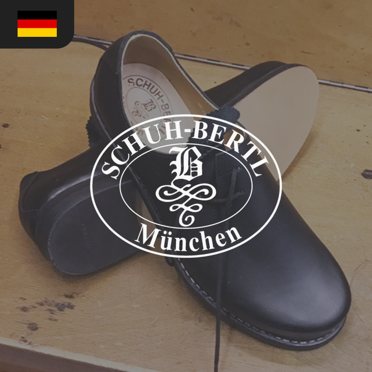 A pair of black leather shoes with a logo reading "SCHUH-BERTL München" prominently displayed.
