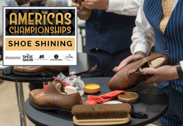 A person holds a polished brown leather shoe while surrounded by shoe shining supplies, including brushes and polish containers.