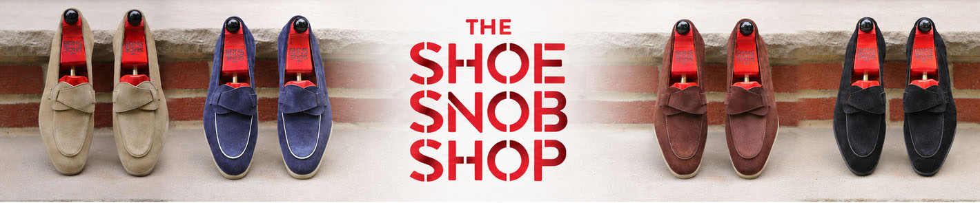 Two pairs of loafers in beige and navy suede, and brown and black suede, with red shoe trees, featured on "The Shoe Snob".