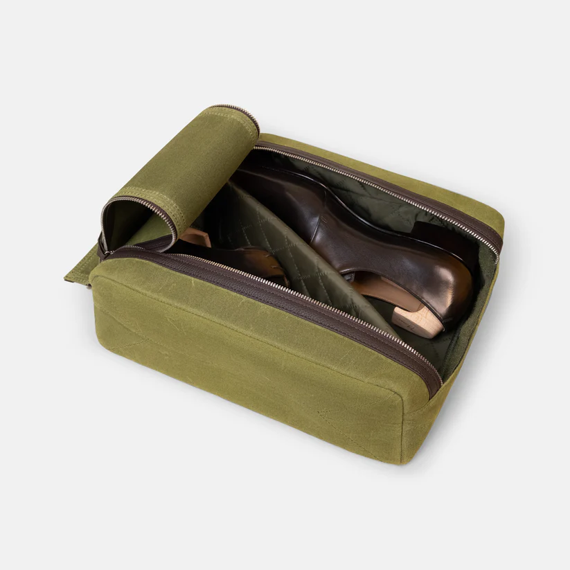 Arterton Signature Shoe Bag in olive green with a zippered opening, containing a pair of brown shoes inside.