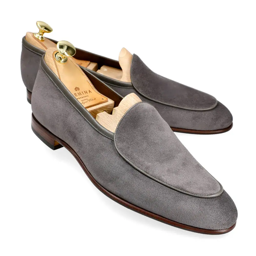 Gray suede loafers with wooden shoe trees inside.