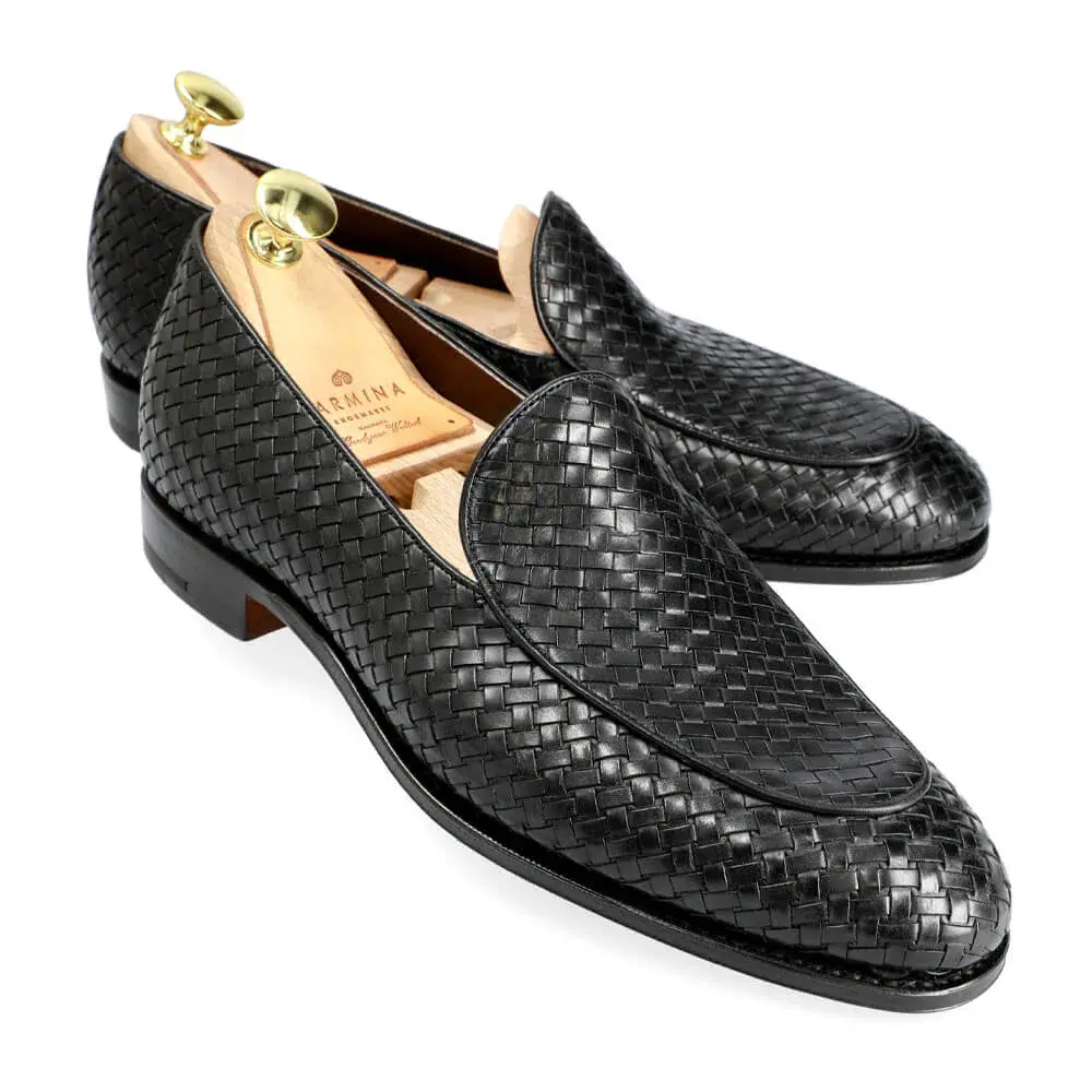 Black woven leather loafers with wooden shoe trees inside.