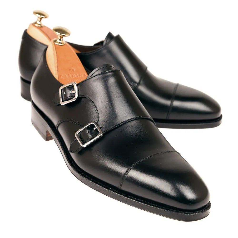 Black leather double monk strap shoes with silver buckles.