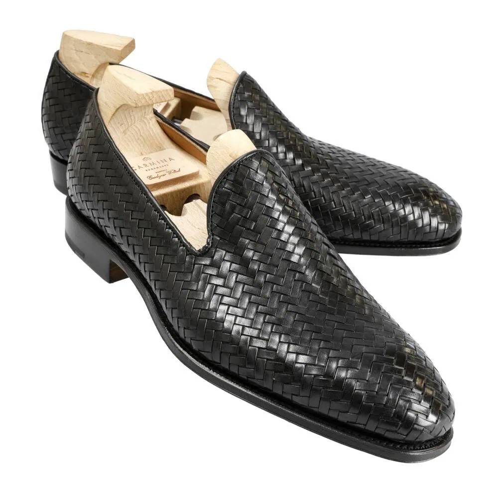 Black woven leather loafers with wooden shoe trees inside.