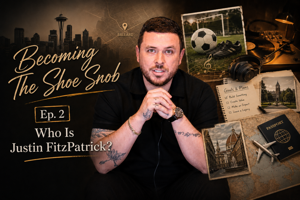 A man with tattoos and a watch sits with hands clasped, wearing a black shirt, against a backdrop of various items including a soccer ball and a passport.