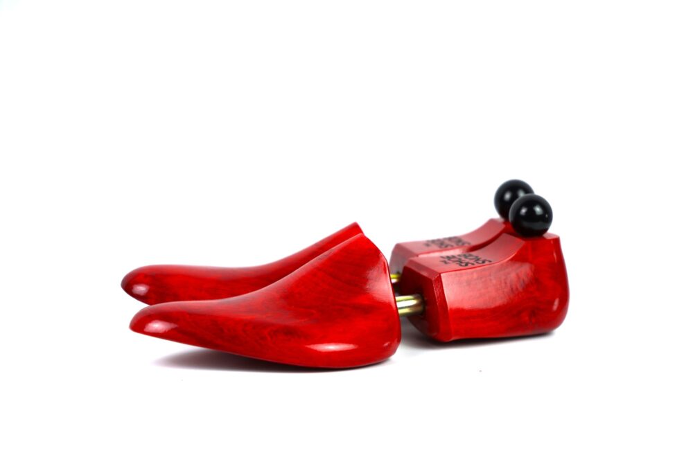 Red wooden shoe trees with black knobs.