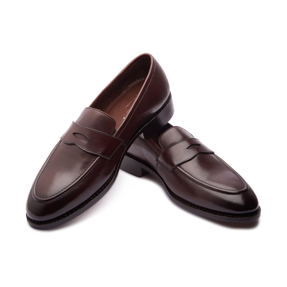 A pair of dark brown leather loafers with a decorative strap across the front.