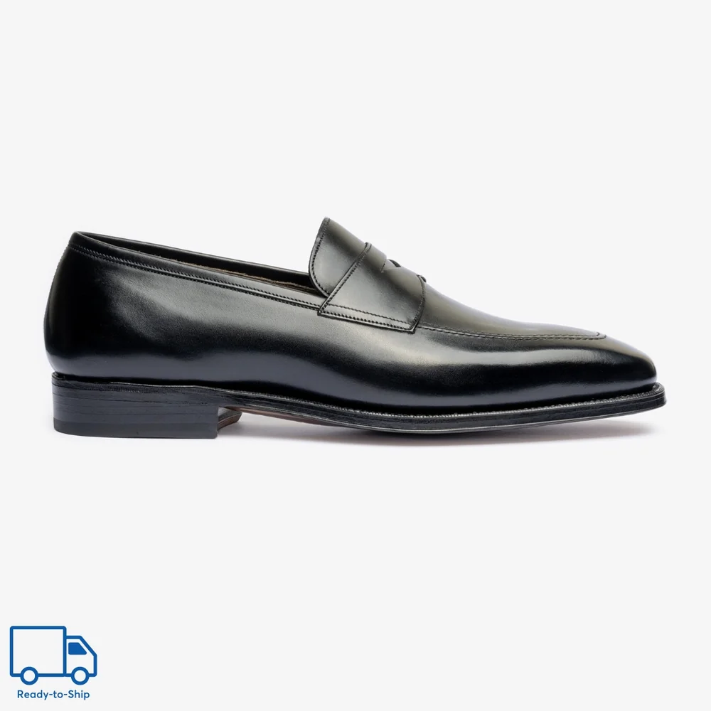 Black leather loafer shoe with a sleek design and a low heel.