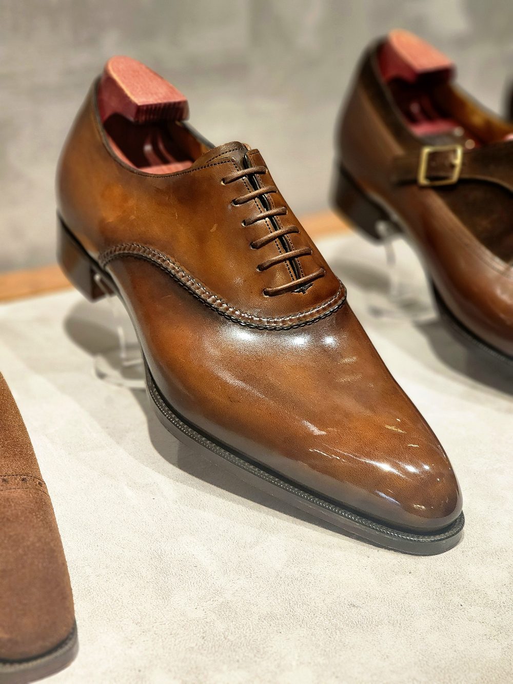 A polished brown leather dress shoe with a lace-up design and a rounded toe.