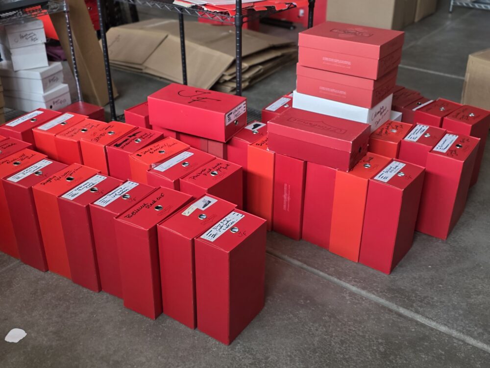 A collection of red storage boxes with labels, stacked and arranged on a flat surface.