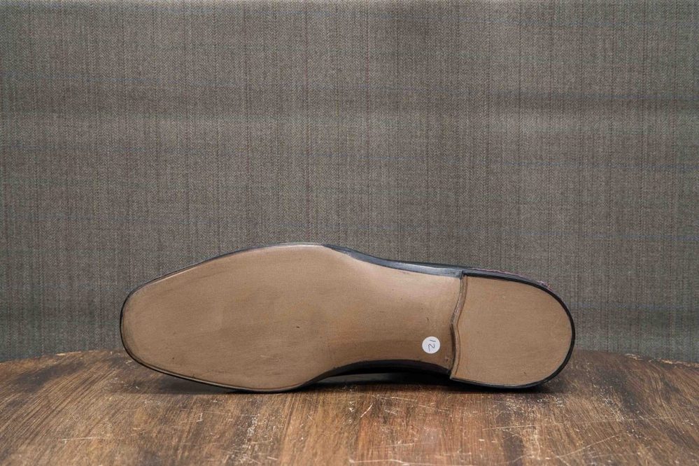 A black shoe sole with a smooth beige bottom and a small white label marked "2."