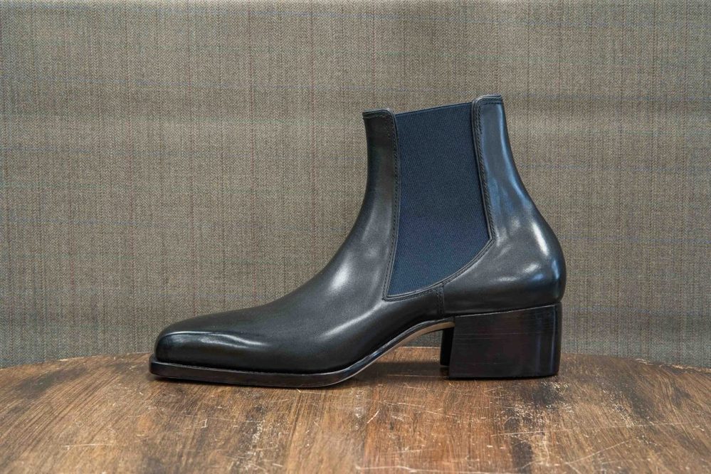 A black leather ankle boot with elastic side panels and a block heel.