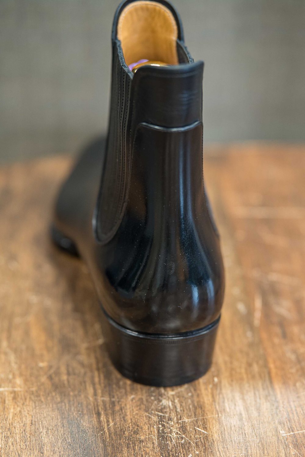 A sleek black leather boot with a smooth finish and a rounded heel.