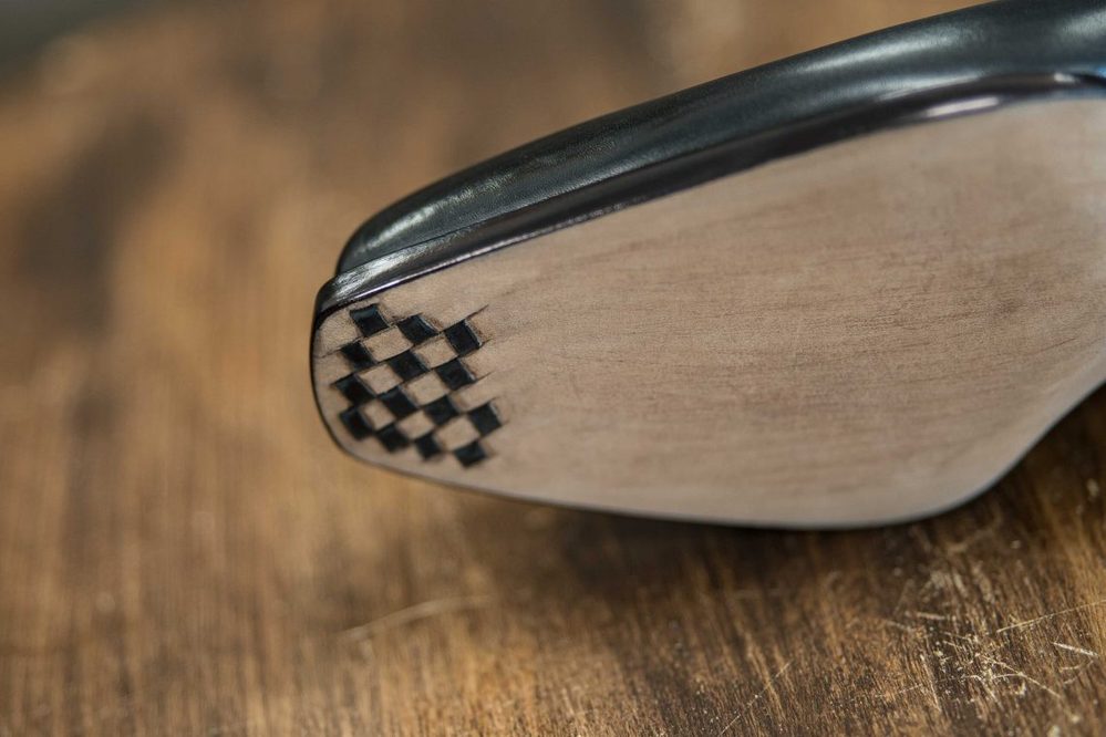 Close-up of a shoe sole featuring a black and gray checkerboard pattern.