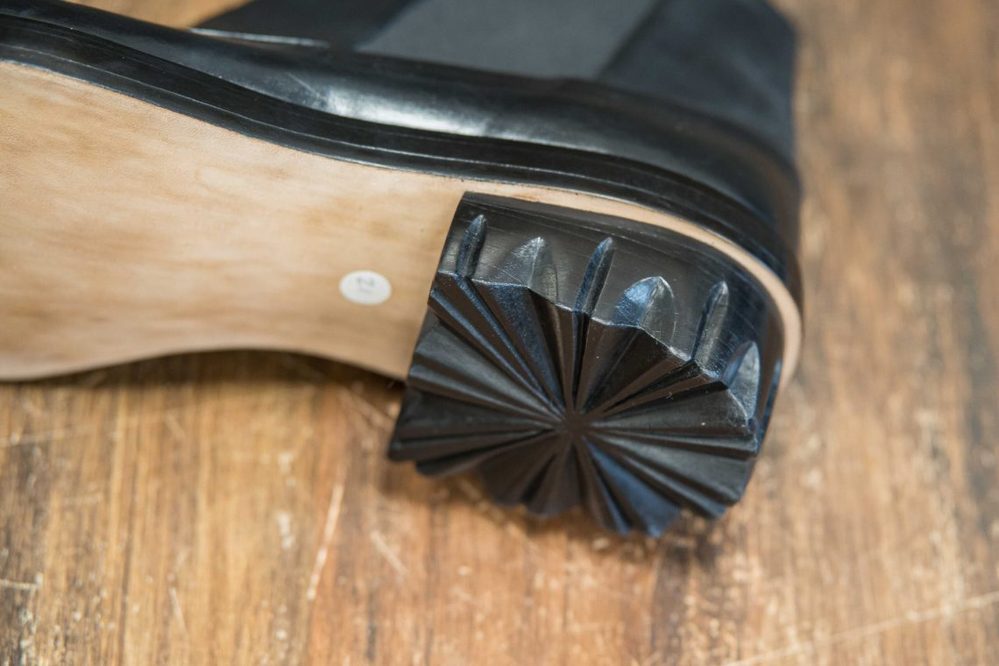 Close-up of a black shoe sole featuring a star-shaped heel design.