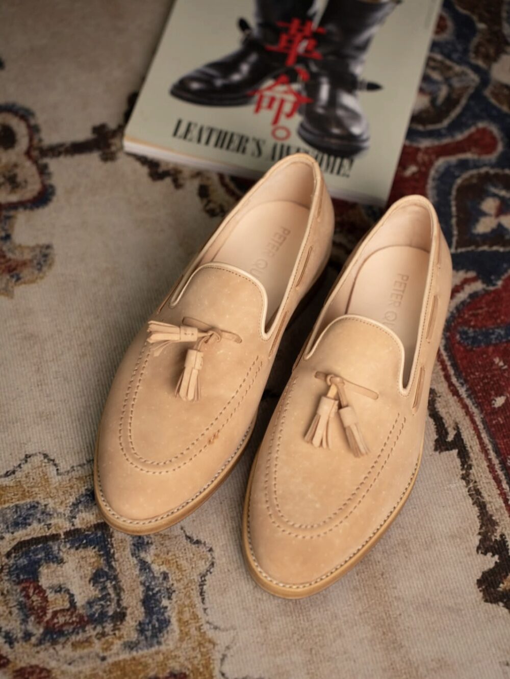 A pair of light tan cordovan shoes with tassels.