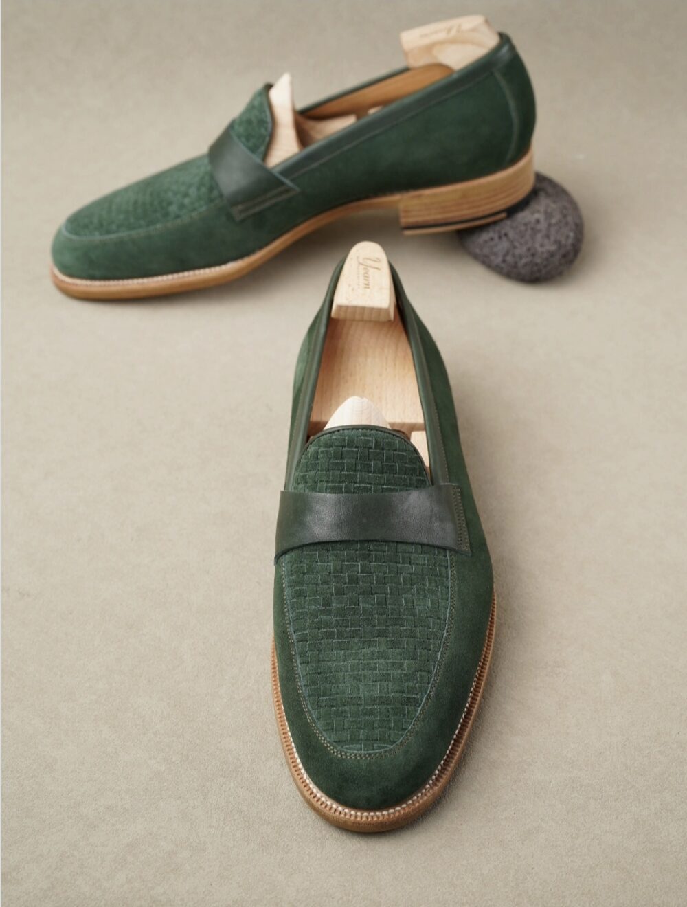 A pair of green Amalfi loafers featuring a woven texture on the front and a smooth leather band.