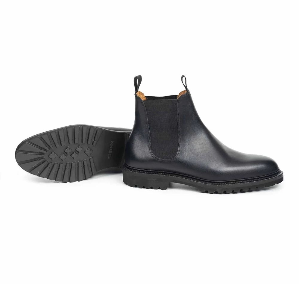 Black leather Chelsea boots with a rubber sole and elastic side panels.