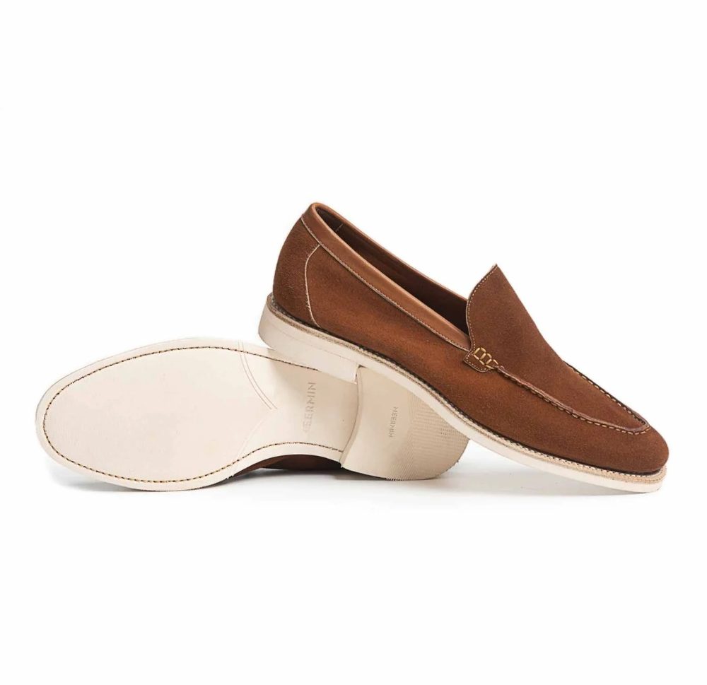Brown suede loafers with a white rubber sole, angled to show both the front and bottom.