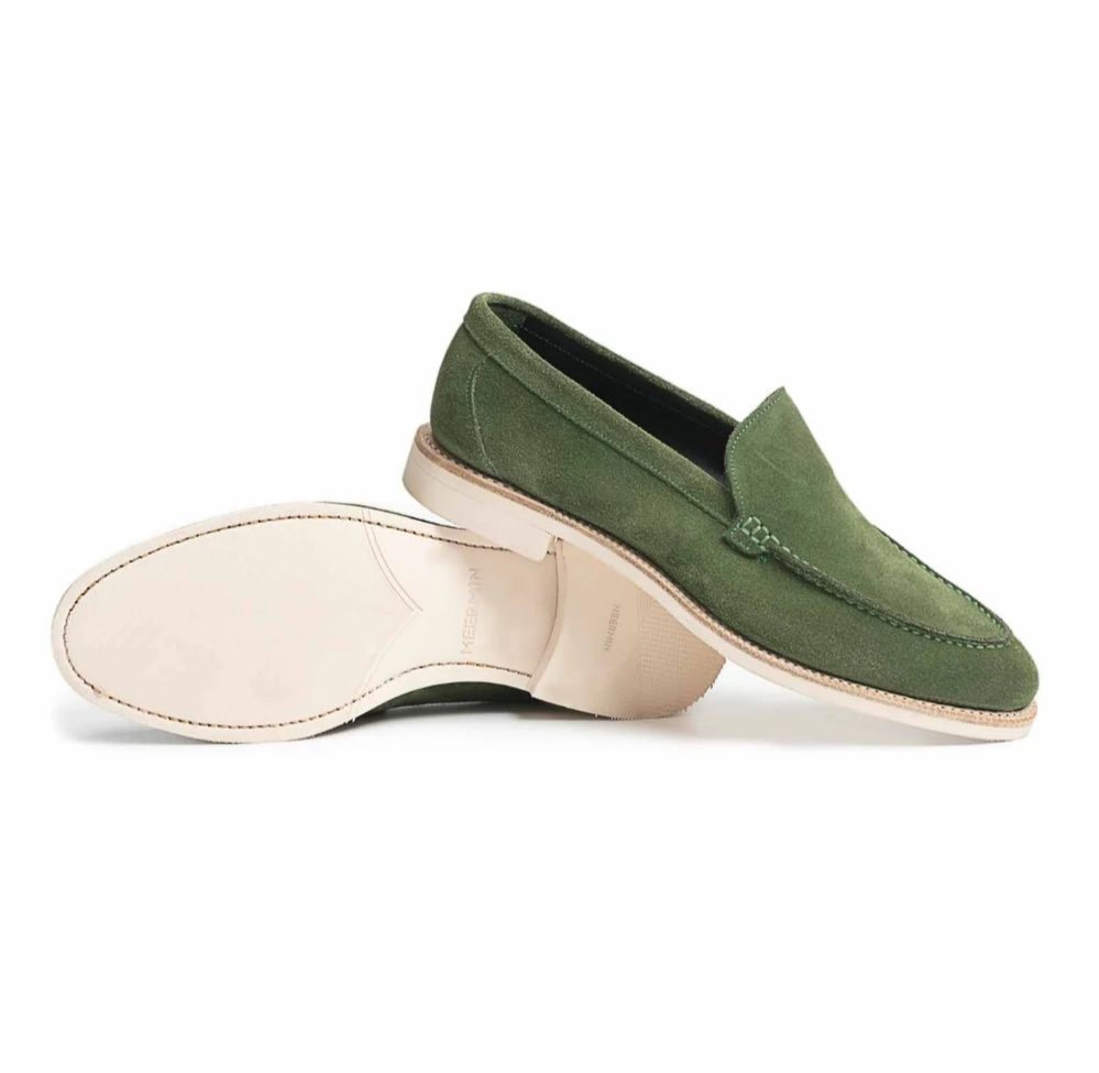 Green suede loafers with a cream-colored sole.