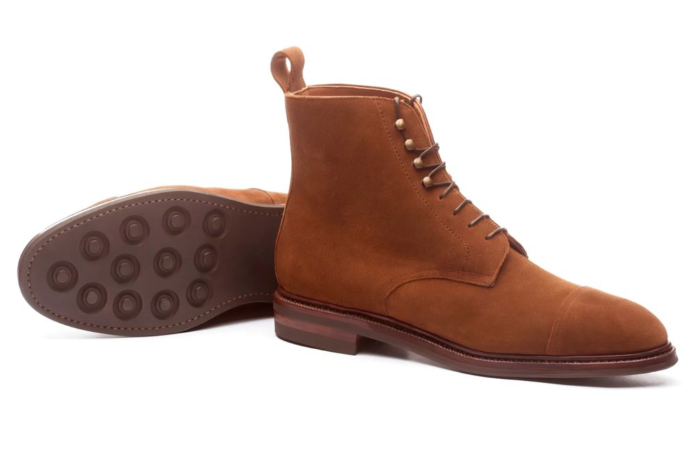 Brown suede ankle boots with a lace-up design and a rubber sole.