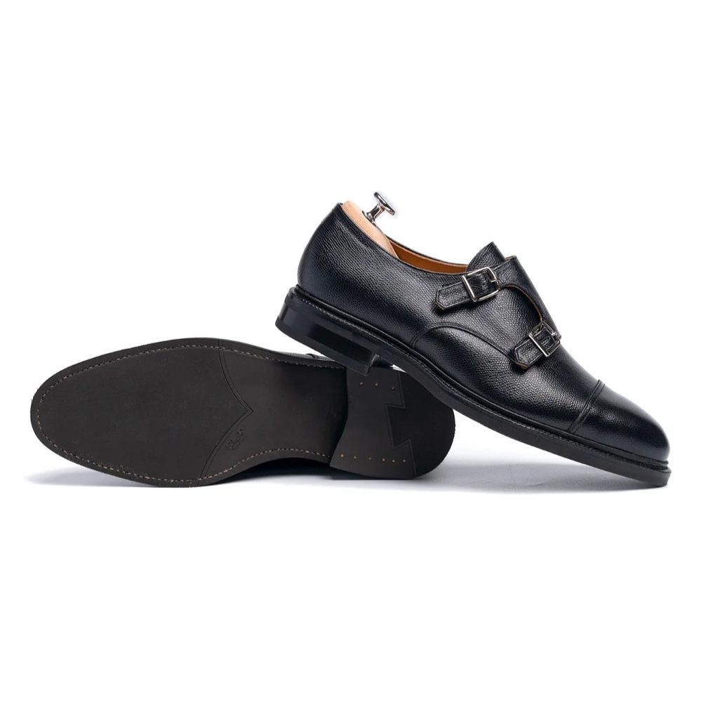 Black leather double monk strap shoes with a sleek design and a smooth sole.