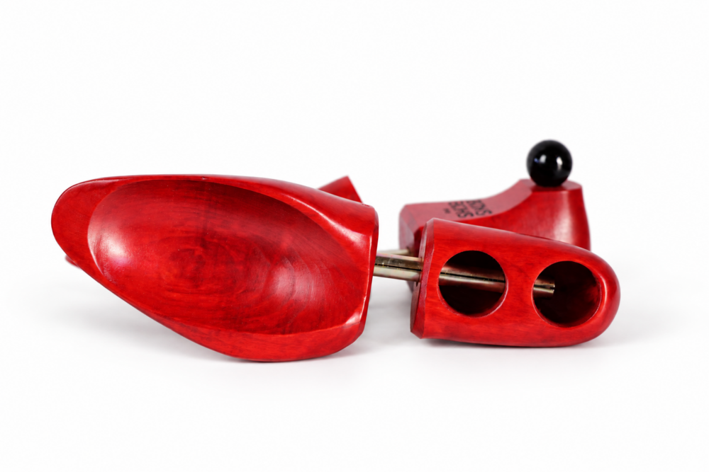 The Shoe Snob's Lightweight Shoe Trees are bright red wooden shoe trees with a metal rod and a black knob.