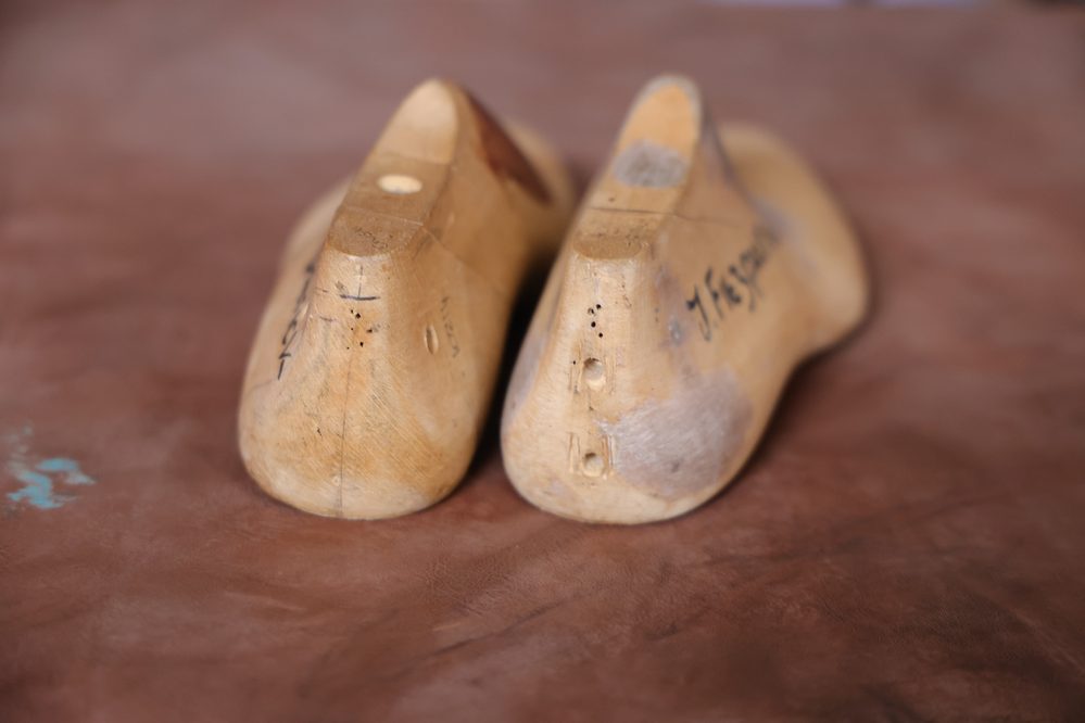 Two wooden shoe lasts with engraved markings, demonstrating what is a shoe last.
