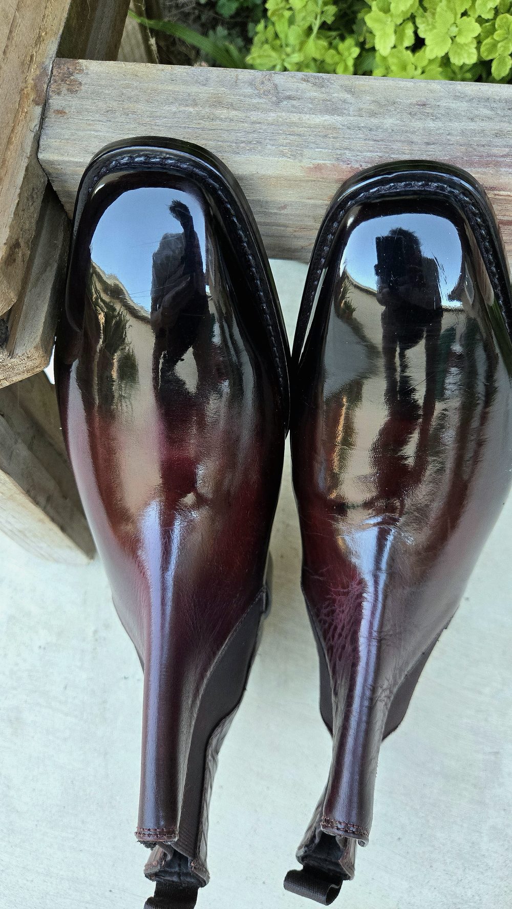 A pair of polished burgundy leather shoes with a glossy finish.