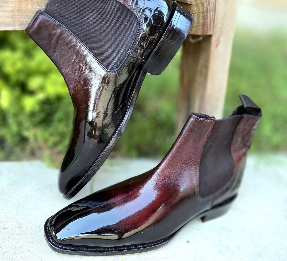 A pair of polished brown leather Chelsea boots with elastic side panels.
