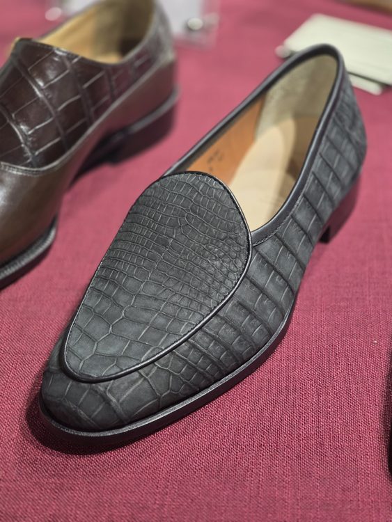 A black crocodile nubuck loafer shoe with a smooth finish and pointed toe design.