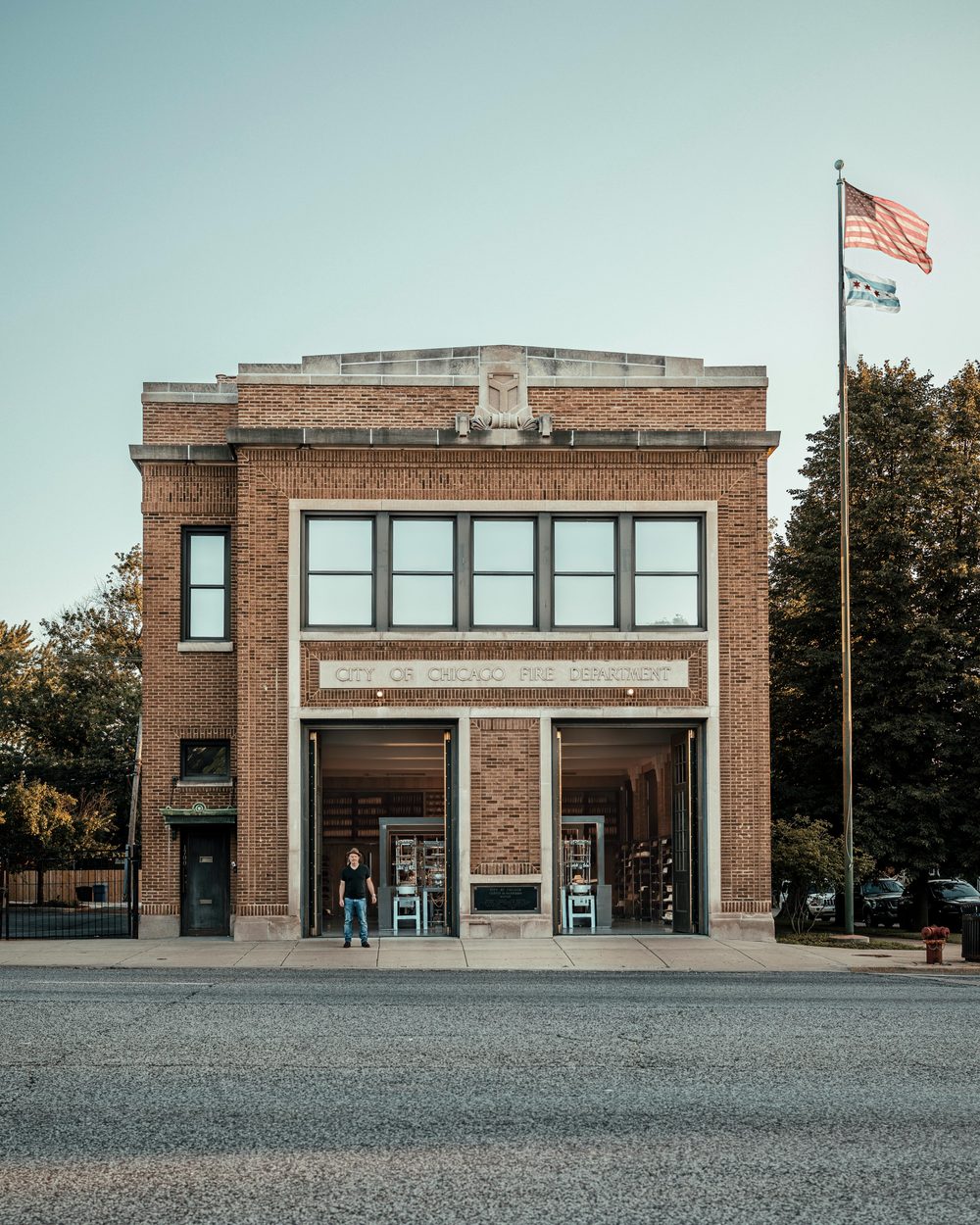 A brick building with large windows labeled "City of Chicago Fire Department" and a person standing in front.