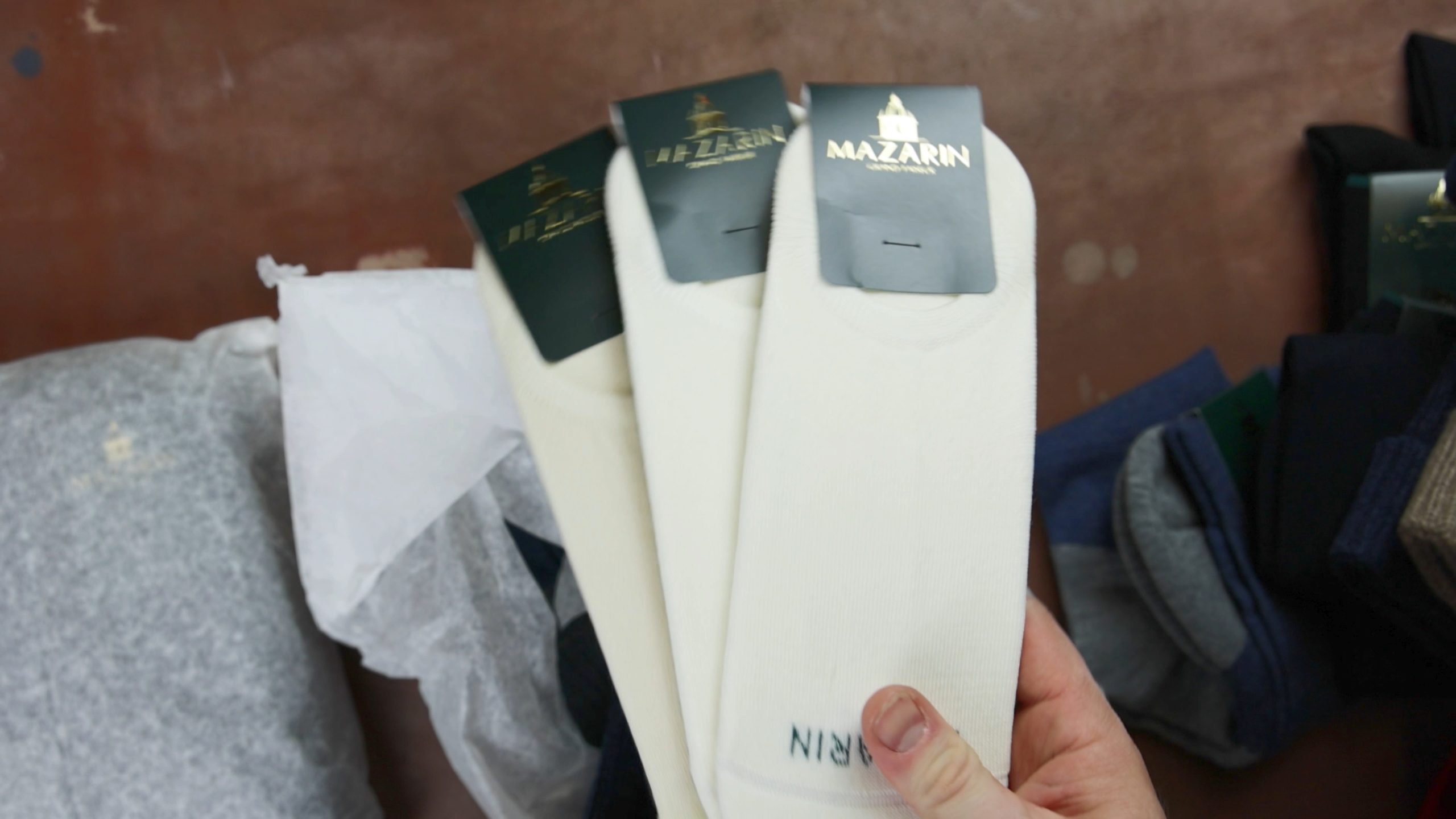 Three pairs of cream-colored socks with black labels featuring the brand name "Mazarin."